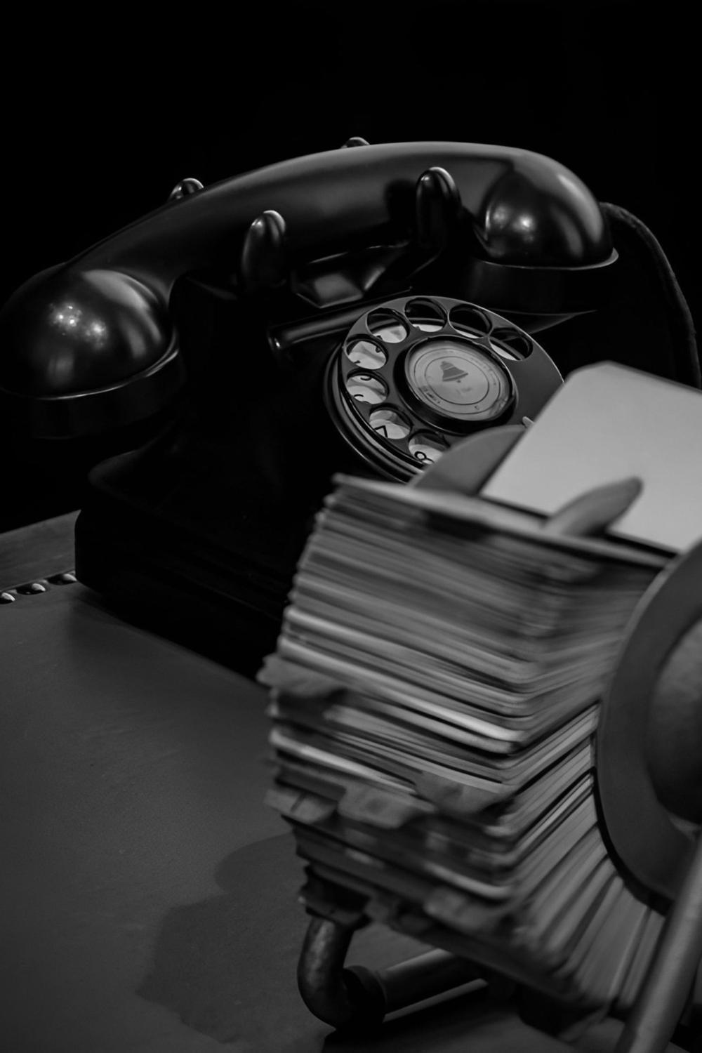 Altes Telefon mit Wählscheibe und Rolodex-Kartei auf einem Schreibtisch